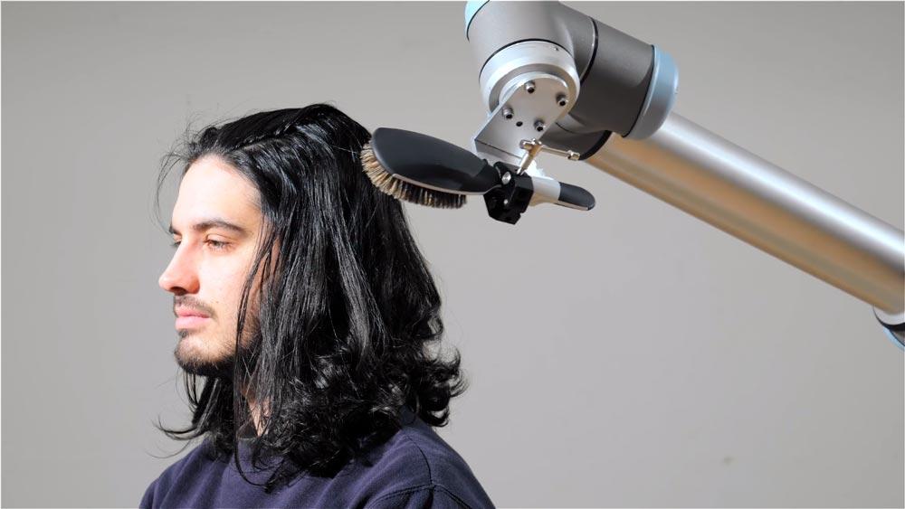 5 EJEMPLOS DE ROBÓTICA COLABORATIVA QUE TE DEJARÁN BOQUIABIERTO 16 Cobot peinando a una persona (ejemplos de robótica colaborativa)